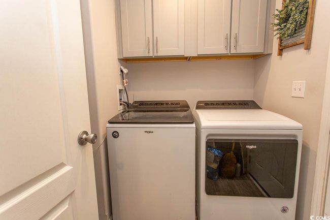 Laundry area featuring washer and clothes dryer and cabinet space | Image 7
