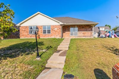 Ranch-style house featuring a front lawn and a playground | Image 1