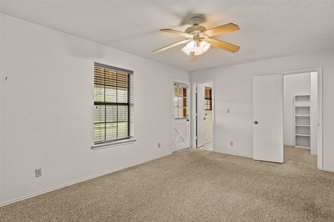 Unfurnished bedroom with a walk in closet, ceiling fan, and carpet | Image 16