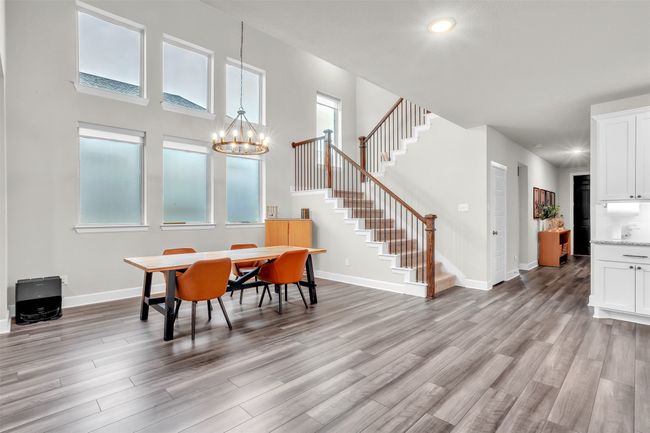 Dining area featuring light wood finished floors, stairway, and baseboards | Image 9