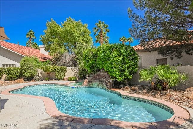 View of swimming pool featuring a pool with connected hot tub and fence | Image 62