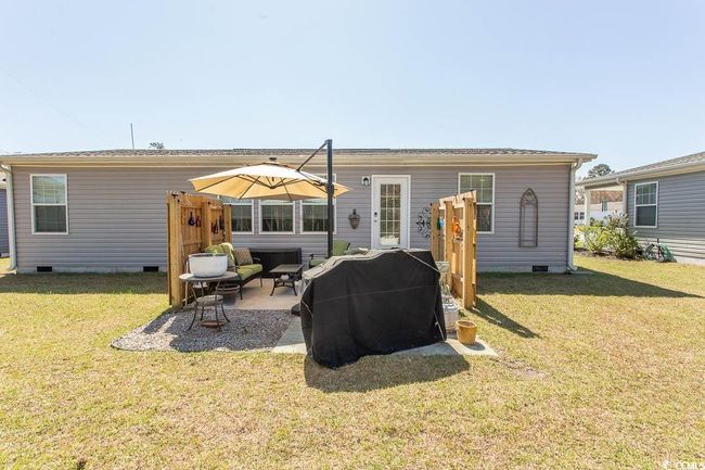 Rear view of property featuring a lawn, a patio area, and crawl space | Image 38
