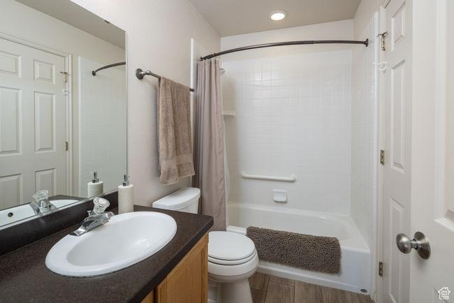 Full bathroom featuring shower / bathtub combination with curtain, vanity, and toilet | Image 22