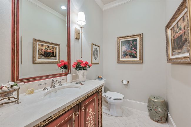 Half bathroom featuring crown molding, vanity, toilet, and baseboards | Image 8