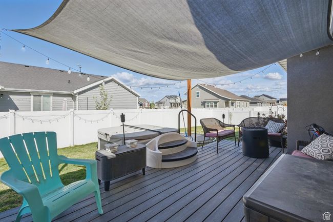 Wooden deck featuring an outdoor fire pit, a fenced backyard, and a residential view | Image 45