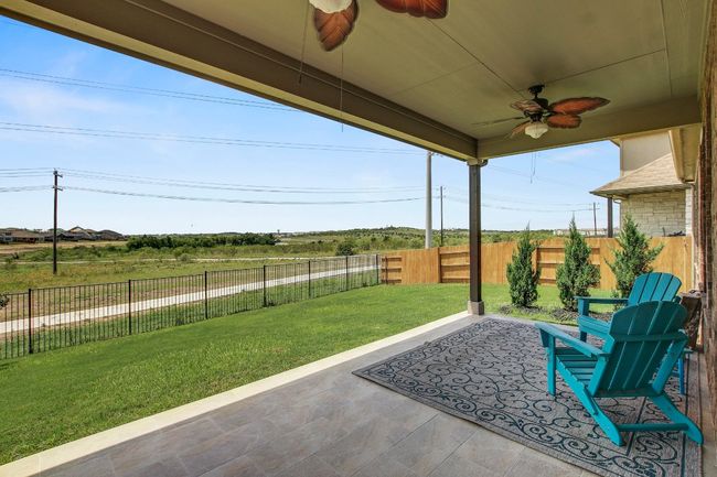 Fenced backyard with a ceiling fan and a covered extended patio area facing greenbelt | Image 31
