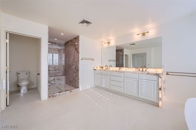 Full bathroom with a marble finish shower, double vanity, visible vents, toilet, and a sink | Image 39
