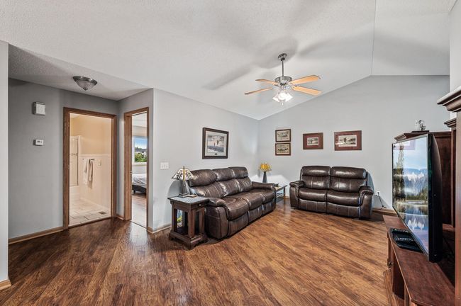 The main level boasts an open layout with vaulted ceilings, neutral colors, and newer laminate flooring. | Image 4
