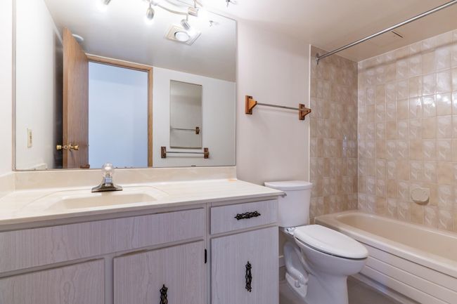 Bathroom featuring vanity, toilet, and shower / washtub combination | Image 15