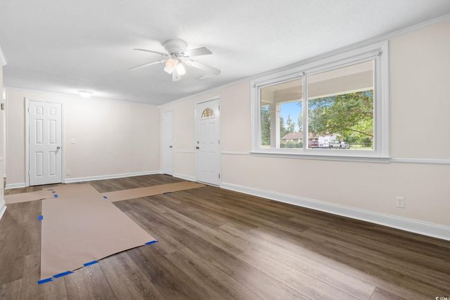 Entrance foyer with wood finished floors, baseboards, ceiling fan, and crown molding | Image 20