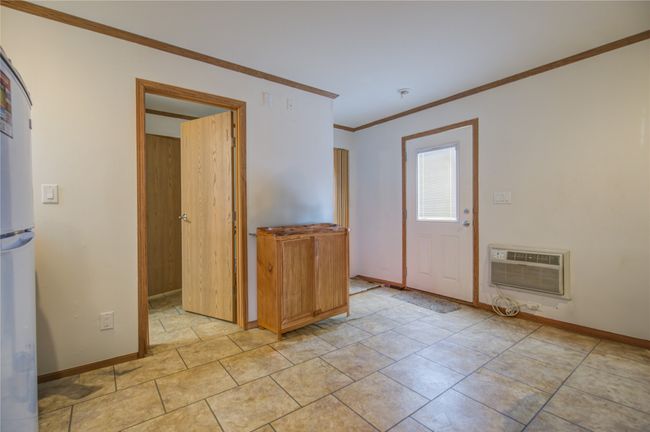 Unfurnished room featuring ornamental molding, baseboards, and a wall mounted air conditioner | Image 4