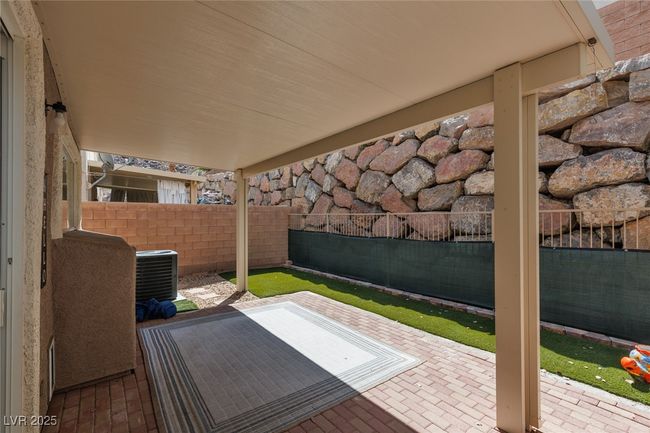 View of patio with a fenced backyard and cooling unit | Image 25