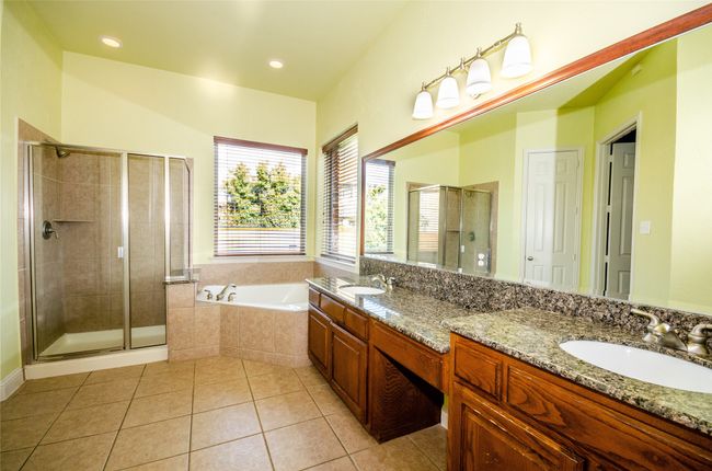 Full bathroom featuring double vanity, tile patterned flooring, a stall shower, and a bath | Image 12