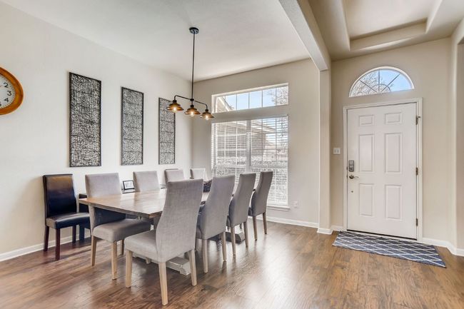 Dining room with dark wood finished floors, plenty of natural light, and a chandelier | Image 6
