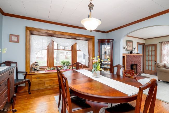 Dining room with arched walkways, plenty of natural light, a fireplace, and light wood-style flooring | Image 10