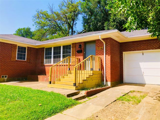 Ranch-style house with a garage, driveway, and brick siding | Image 27