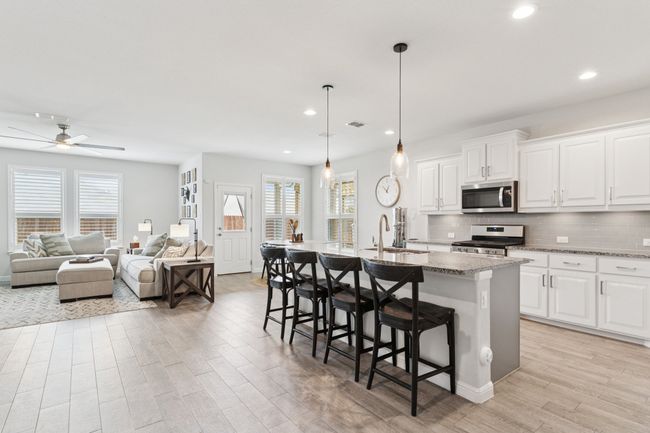Kitchen featuring appliances with stainless steel finishes, light wood-type flooring, plenty of natural light, a breakfast bar, and recessed lighting | Image 9