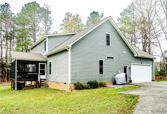 View of side of home with a sunroom, a garage, crawl space, and a yard | Image 34