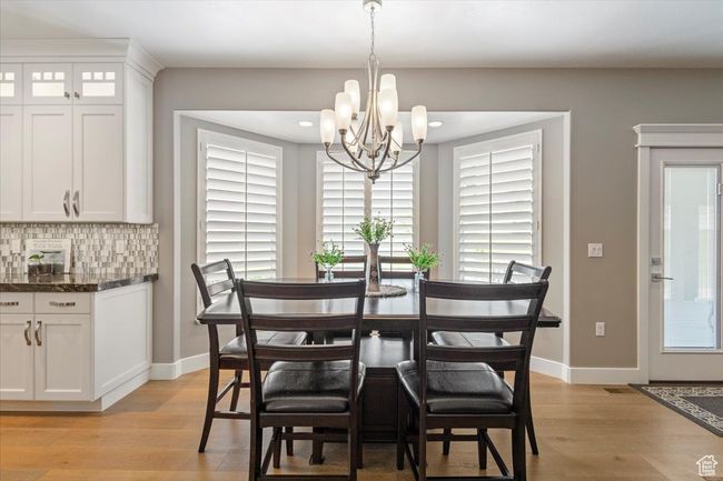 Dining area featuring a chandelier, light wood-type flooring, baseboards, and recessed lighting | Image 12
