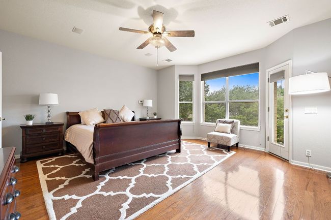 The primary bedroom has beautiful wood floors, a big bay window that overlooks the backyard, and tall ceilings! | Image 9