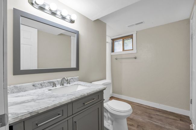 Bathroom featuring vanity, visible vents, toilet, wood finished floors, and baseboards | Image 27
