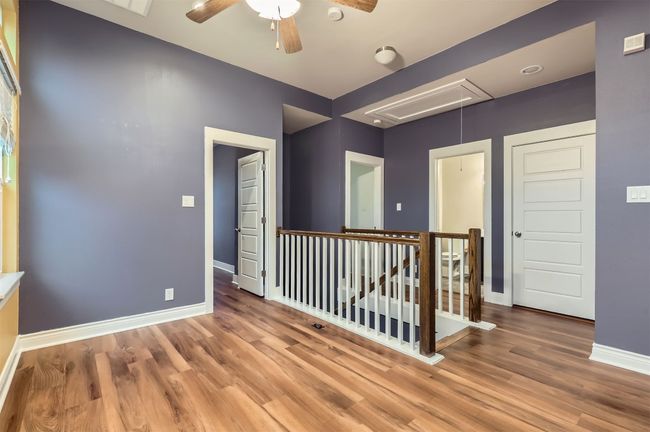 Spare room with attic access, wood finished floors, and a ceiling fan | Image 23