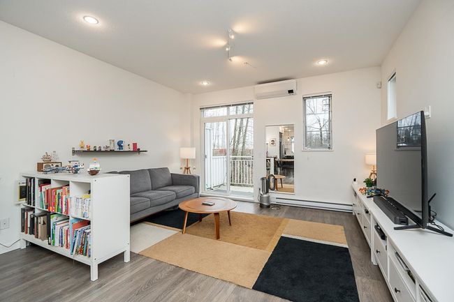 Living room featuring recessed lighting, a wall mounted air conditioner, baseboard heating, and wood finished floors | Image 5