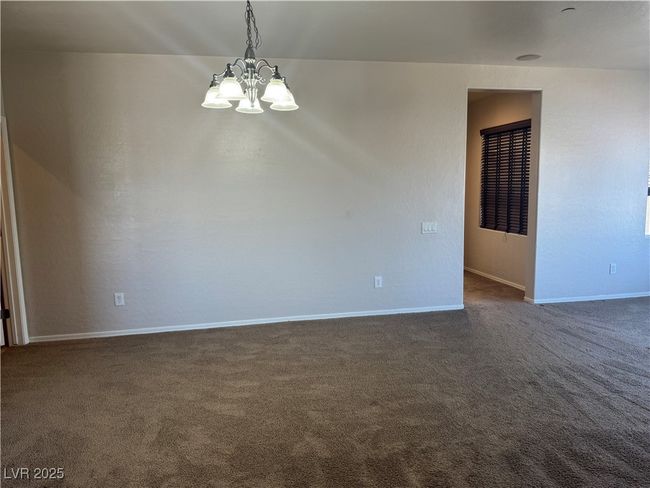 Unfurnished room with a chandelier and dark carpet | Image 9