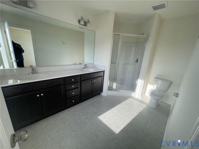 Bathroom with light tile patterned flooring, a stall shower, and double vanity | Image 10