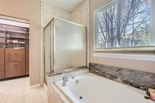 Primary ensuite bath with soaking tub and separate shower. Take a bubble bath with the feel of being in the woods. Look at those trees outside your window! | Image 11
