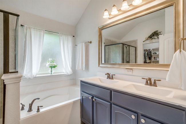 Full bath featuring vaulted ceiling, a bath, double vanity, and a shower stall | Image 21