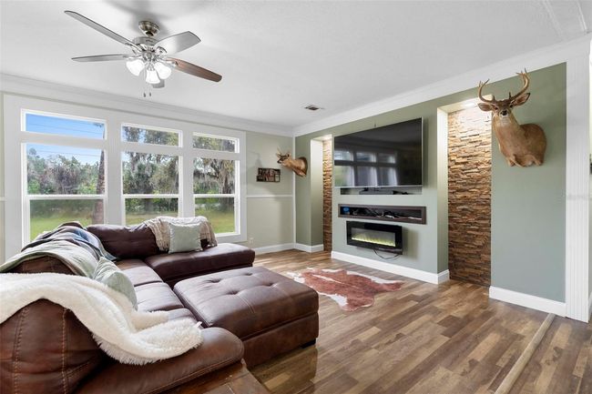 Family room over looking front yard, electric fireplace surrounded by custom stacked stone wall | Image 4