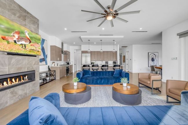 Living room featuring ceiling fan, light wood-type flooring, and a tiled​​‌​​​​‌​​‌‌​‌‌​​​‌‌​​‌‌​‌​​​​​‌ fireplace | Image 23