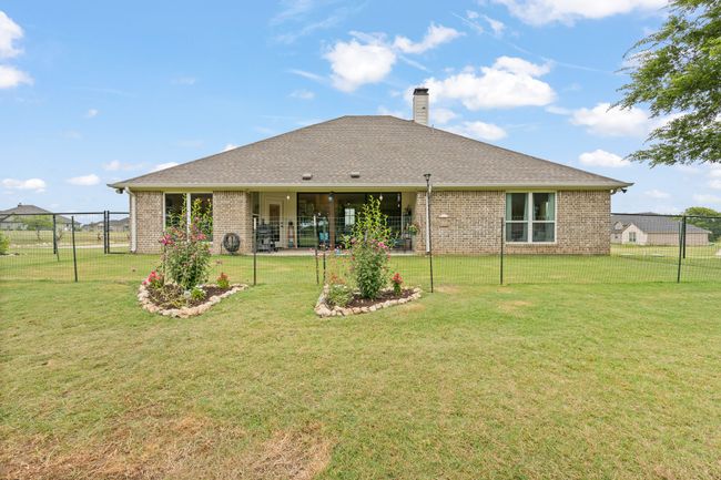 Back of property with brick siding, a fenced backyard, a chimney, and a patio | Image 28