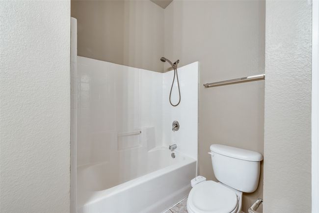 Full bathroom with shower / washtub combination and a textured wall | Image 23