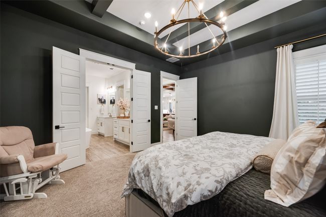 Bedroom with a chandelier, light colored carpet, and connected bathroom | Image 23