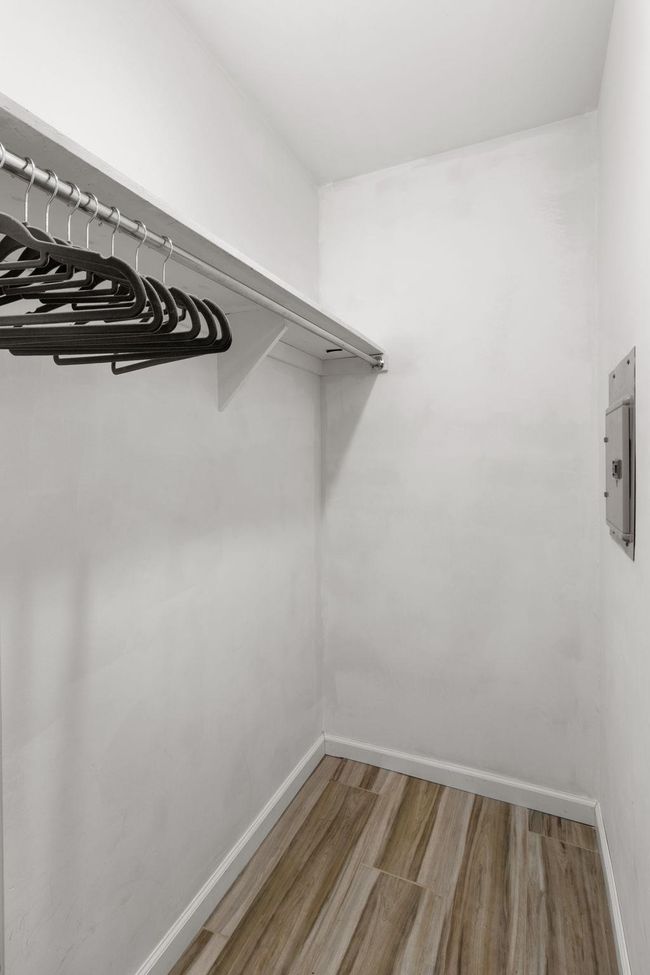 Spacious closet featuring light wood-style floors and electric panel | Image 9