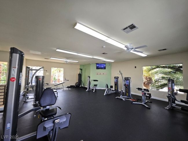 Exercise room featuring ceiling fan, baseboards, and visible vents | Image 17