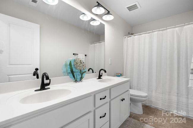 Full bath #2 on upper level with tub/shower combo and double vanity. Tile flooring. | Image 26