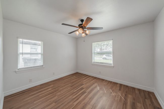 Spare room featuring wood finished floors, baseboards, and ceiling fan | Image 28