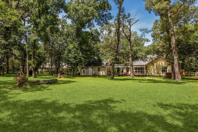 Charming two-story home with a welcoming front porch, nestled among mature trees. Features dormer windows, a classic gable roof, and a spacious yard, perfect for enjoying nature and outdoor activities. | Image 15