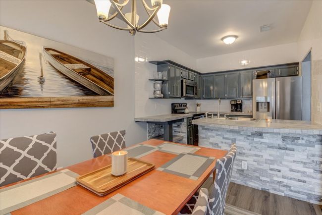 Dining space with a chandelier and wood finished floors | Image 5