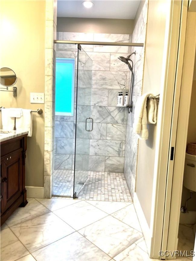 Bathroom with marble look tile flooring, vanity, a shower stall, and recessed lighting | Image 13