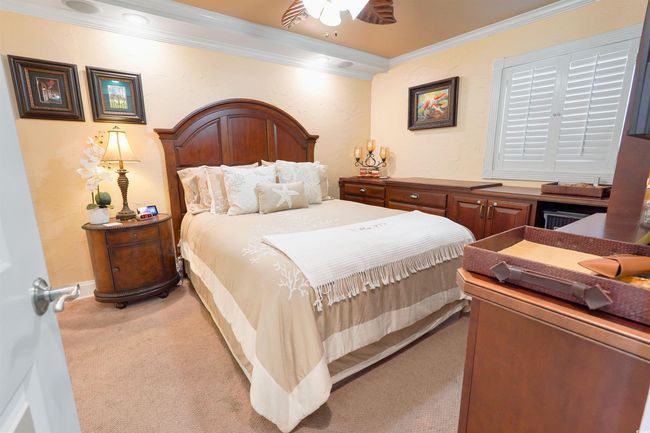 Carpeted bedroom with crown molding, ceiling fan, and baseboards | Image 26