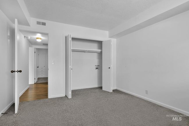 Unfurnished bedroom featuring carpet, a closet, and a textured ceiling | Image 19