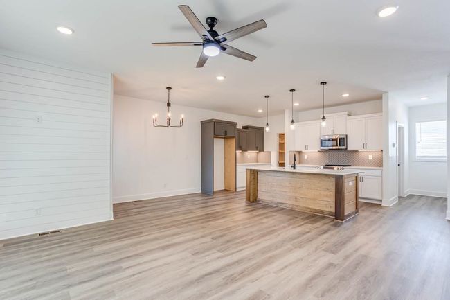 Kitchen featuring stainless steel microwave, recessed lighting, backsplash, baseboards, and light countertops | Image 6