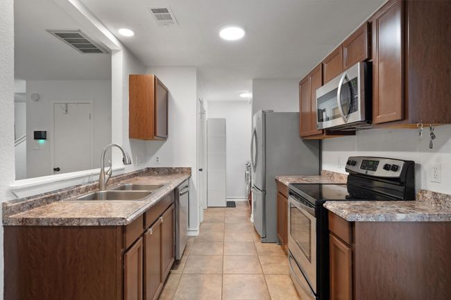 Kitchen featuring appliances with stainless steel finishes, light tile patterned flooring, recessed lighting, and a peninsula | Image 14