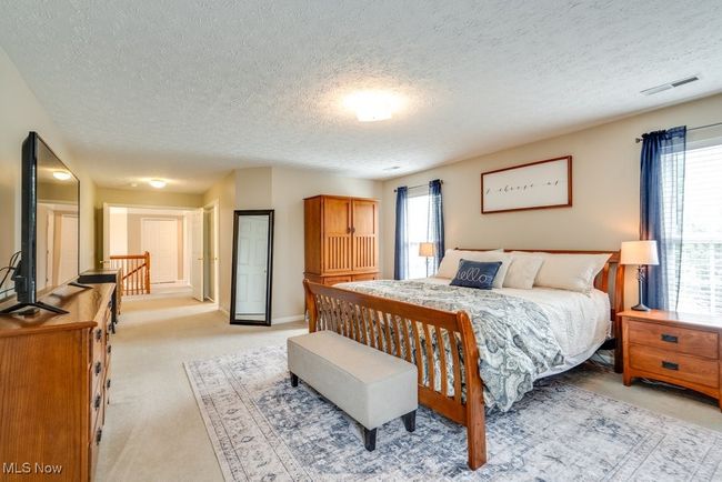 Bedroom with light colored carpet and a textured ceiling | Image 23