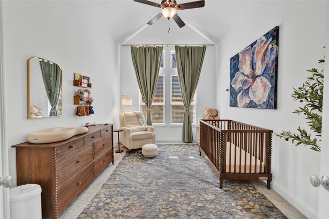 Bedroom with light carpet, a crib, baseboards, ceiling fan, and lofted ceiling | Image 20