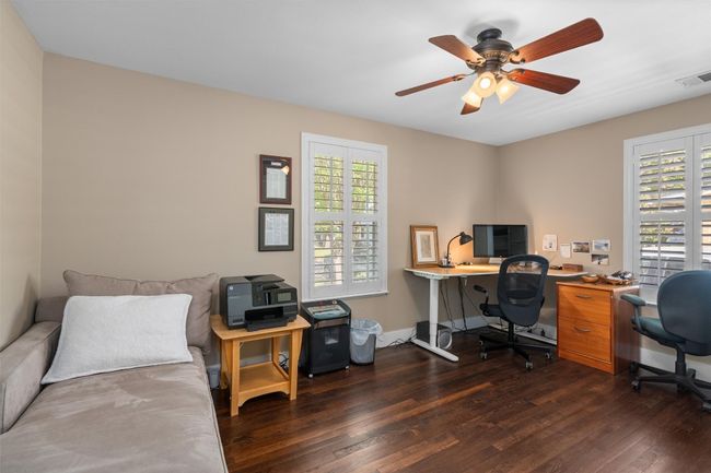 Office area featuring baseboards, visible vents, a ceiling fan, and dark wood-style flooring | Image 18
